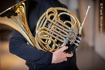 Eine Person hält ein Horn.