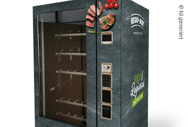 Verkaufsautomat mit Bildern von Fleisch und Gemüse, Aufschrift „Frisch & Regional rund um die Uhr“ und Bedienfeld.