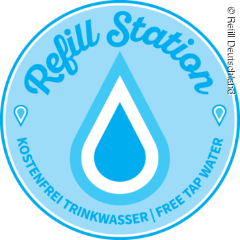 Blauer runder Aufkleber mit Wassertropfen und Text „Refill Station, kostenfrei Trinkwasser, free tap water“.